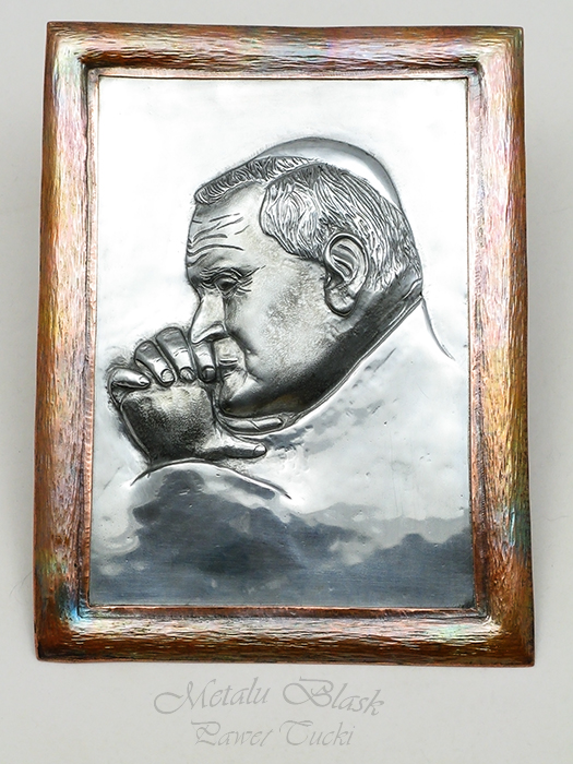 Repusowany wizerunek Jan Pawła II w blasze tytan-cynk. Rama miedziana. Wymiary razem z ramką 190 mm x 140 mm.
